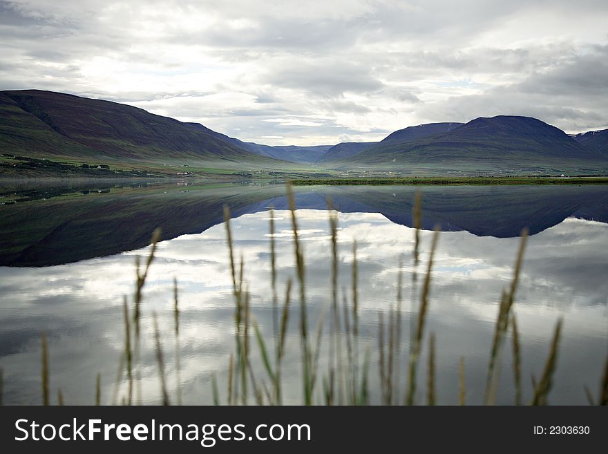 Tranquil lake with grass in the foreground Iceland. Tranquil lake with grass in the foreground Iceland