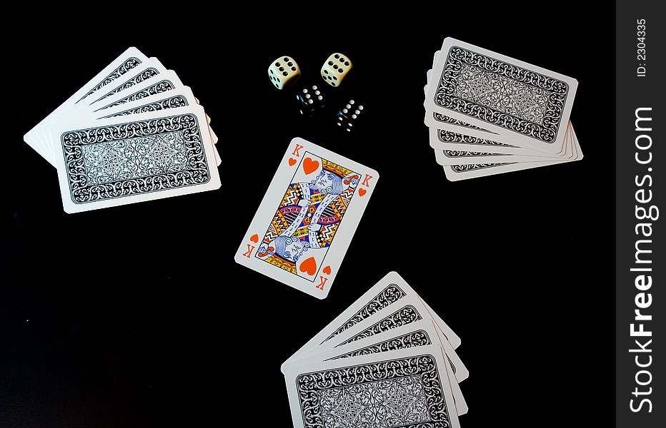 Playing cards and dices on black background