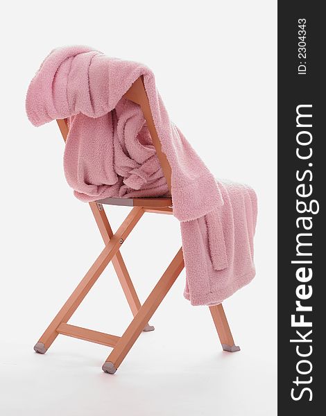 A pink dressing-gown is on the chair. isolated