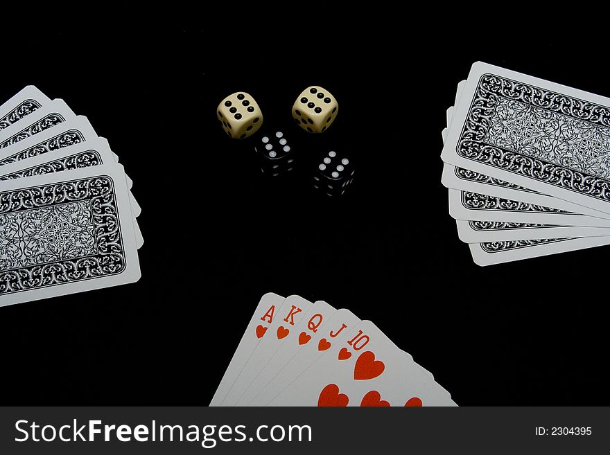 Playing cards and dices on black background