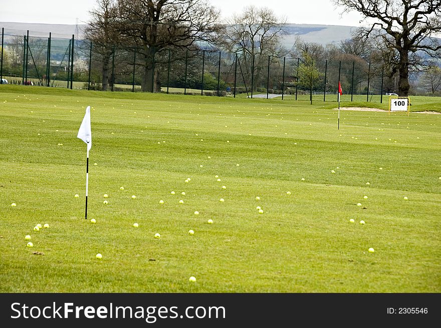 A view of a driving range with flags fluttering in the wind. A view of a driving range with flags fluttering in the wind