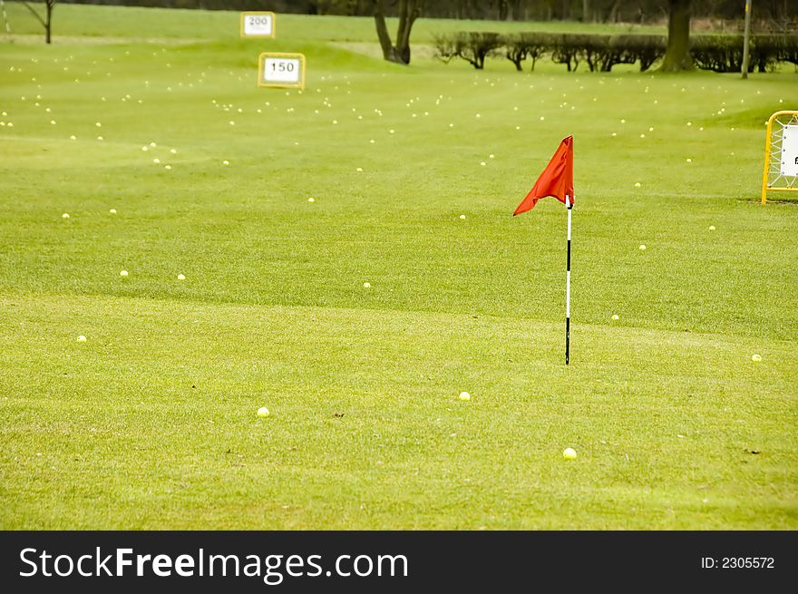 A view of a driving range with flags fluttering in the wind. A view of a driving range with flags fluttering in the wind