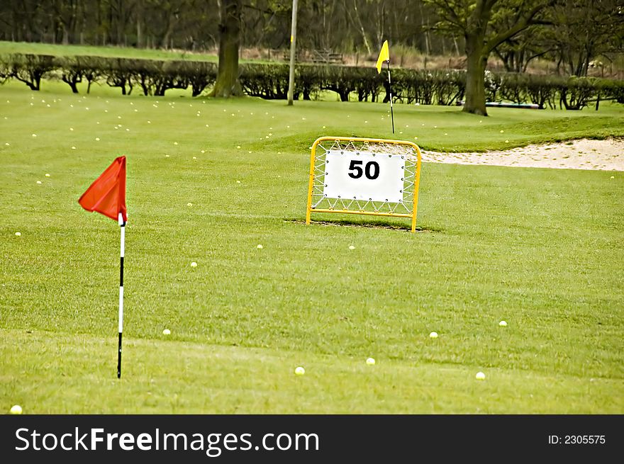 A view of a driving range with flags fluttering in the wind. A view of a driving range with flags fluttering in the wind