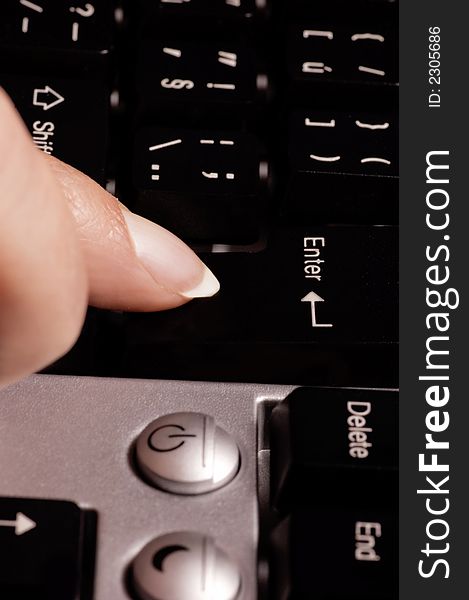 Female finger pushing the button enter on computer keyboard. Female finger pushing the button enter on computer keyboard