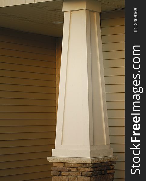 Closeup of a house with a tapered post holding up an overhang. Closeup of a house with a tapered post holding up an overhang