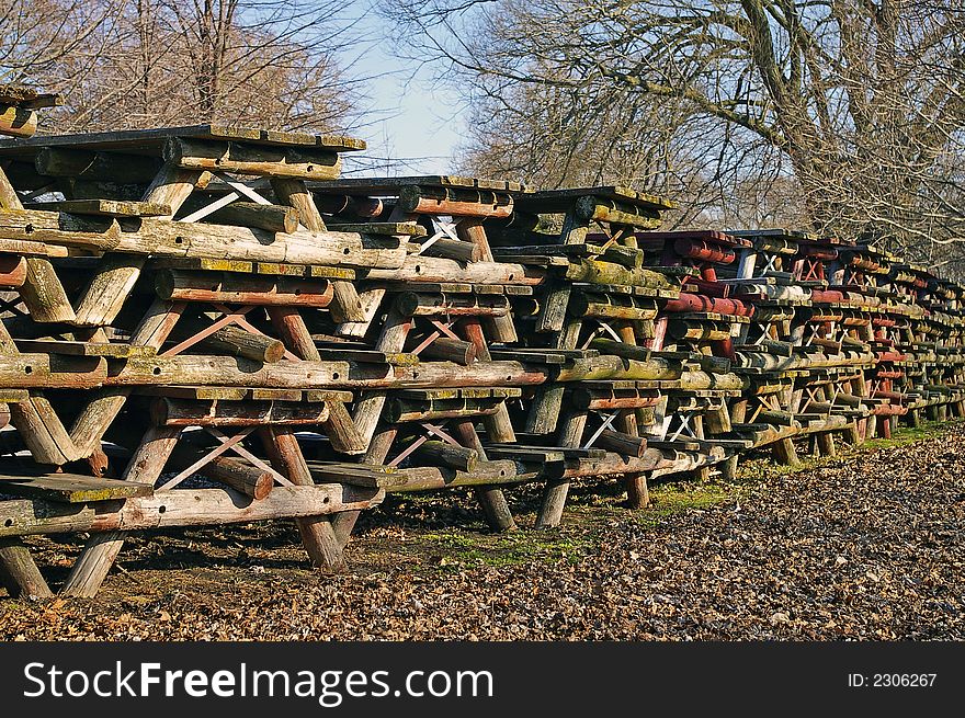 Large quantity of wooden Pincic Tables piled for off-season storage. Large quantity of wooden Pincic Tables piled for off-season storage.