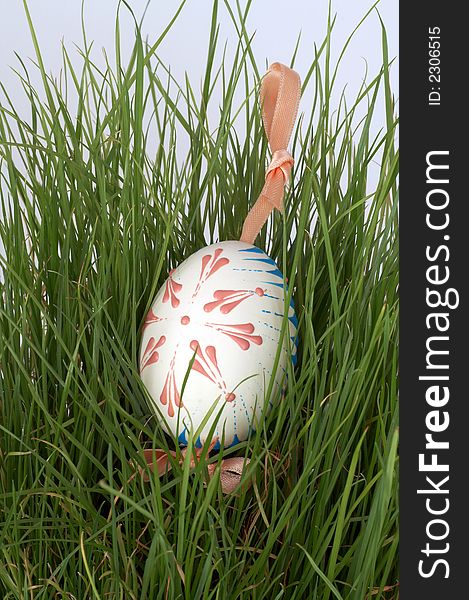 One easter egg with ribbon in grass. One easter egg with ribbon in grass