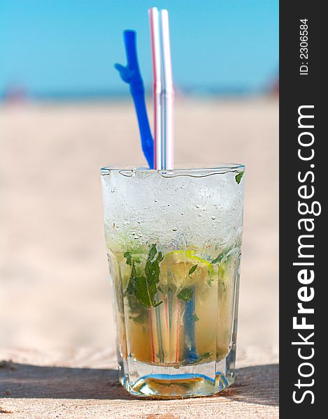 Mojito cocktail on a beach-rum, sugar, mint, soda, ice,