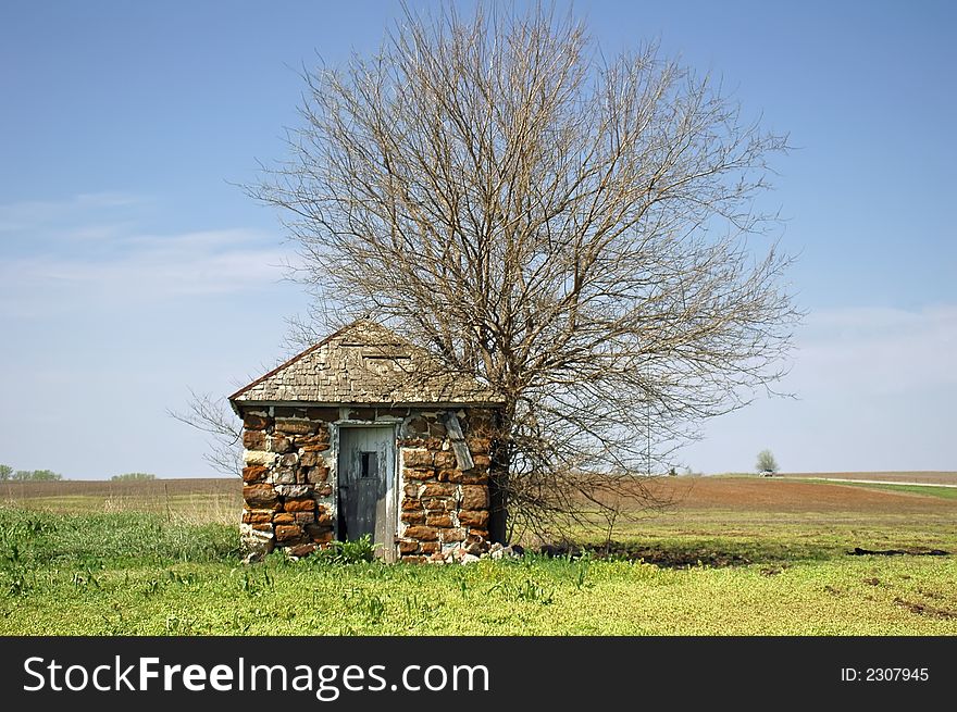 Old farm building made of stone in a green field. Old farm building made of stone in a green field.