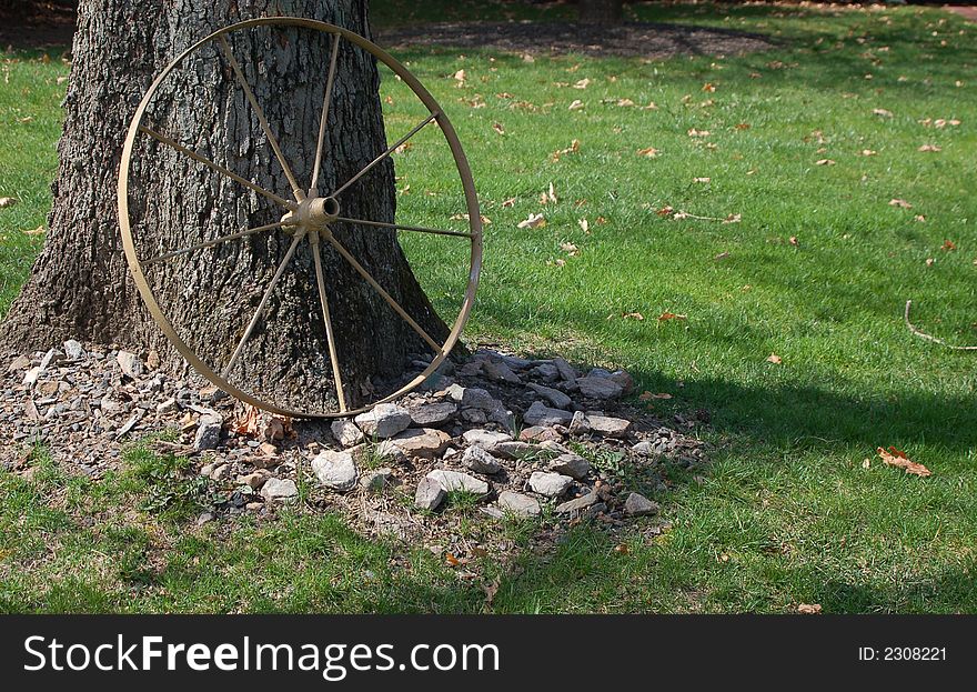 Old wagon wheel against a tree