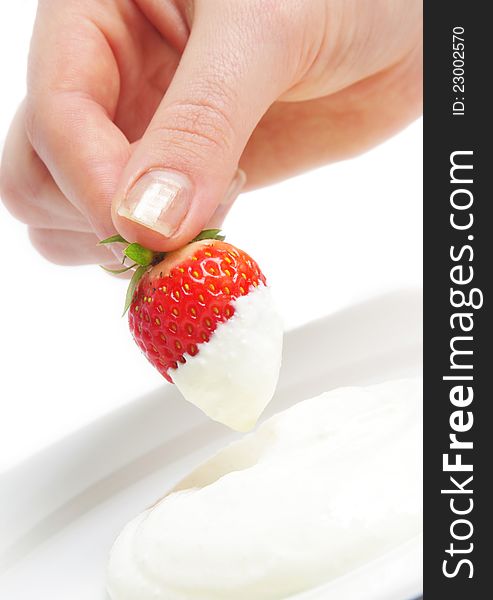 Strawberry in hand with cream over white. Strawberry in hand with cream over white