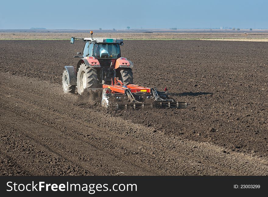 Tractor plowing the fields in spring