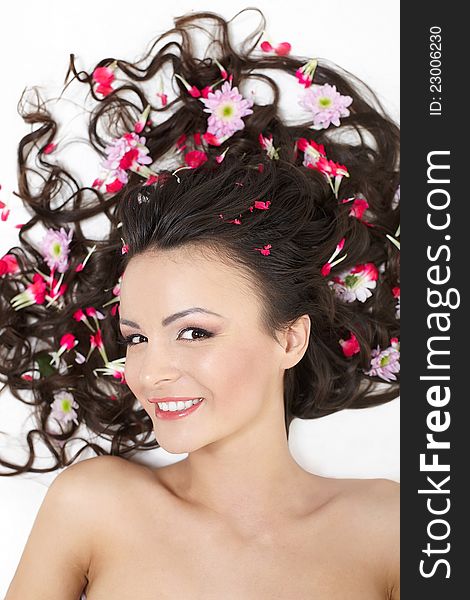 Smiling Girl lying with red flowers in her hair