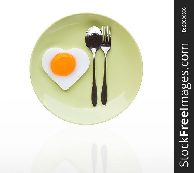 Fried egg heart and spoon