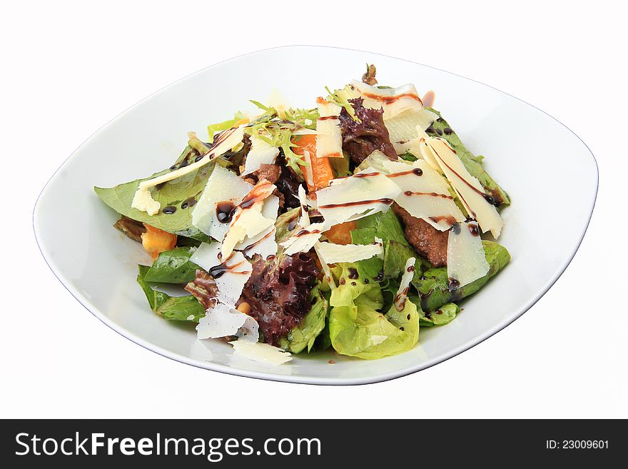 Salad with chicken liver and orange honey dressing in white dish isolated on a white background