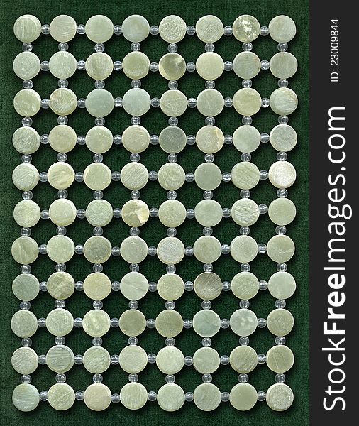 Grid of nephrite discs on green velvet. High resolution texture.