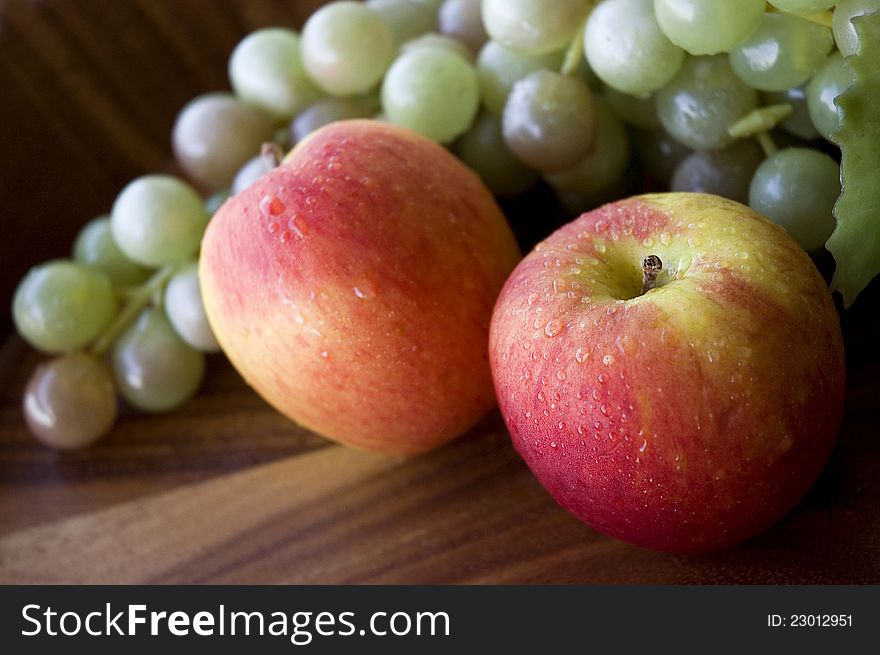 Close up fresh apples with water drop and grapes background. Close up fresh apples with water drop and grapes background