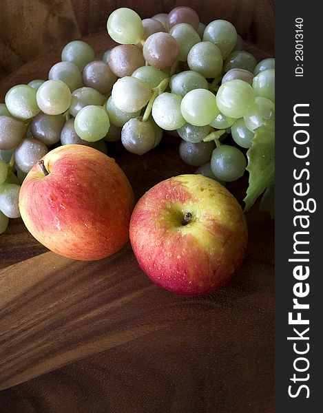 Apples and grapes in wooden tray on top view. Apples and grapes in wooden tray on top view