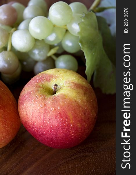 Close up red apple with grapes on tray