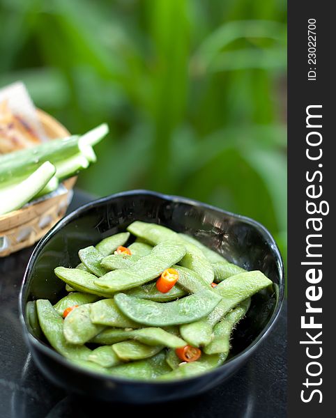 Green beans with red chilli in black ceramic bowl. Green beans with red chilli in black ceramic bowl