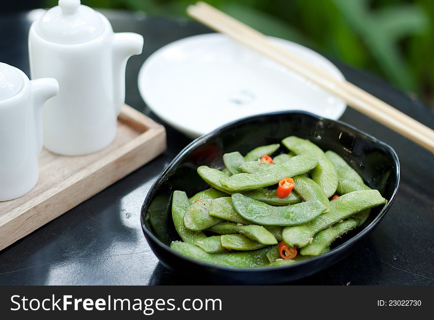 Green beans with red chilli in black ceramic bowl. Green beans with red chilli in black ceramic bowl