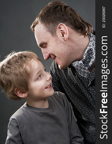 Father and son cheerfully talk. On a gray background.