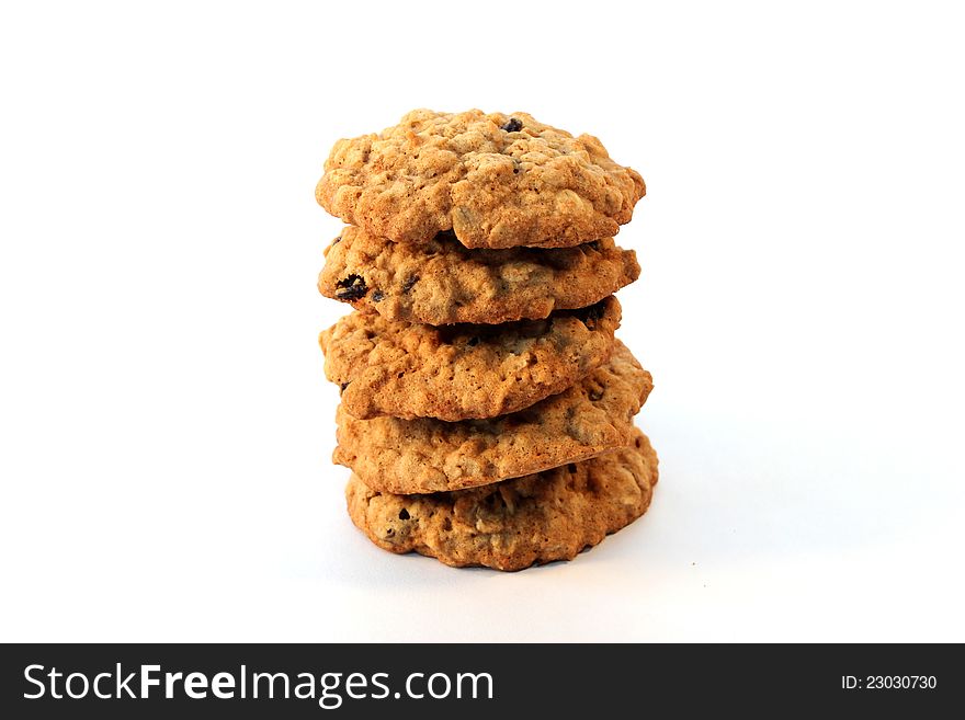 A stack of five homemade oatmeal raisin cookies on white background.