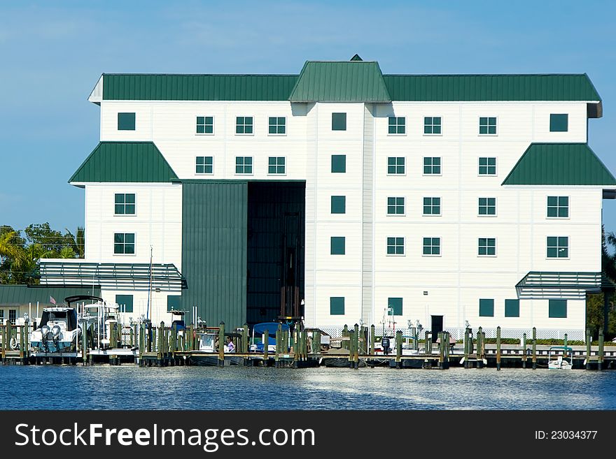 A large white boathouse with door open overlooks bay in florida. A large white boathouse with door open overlooks bay in florida.