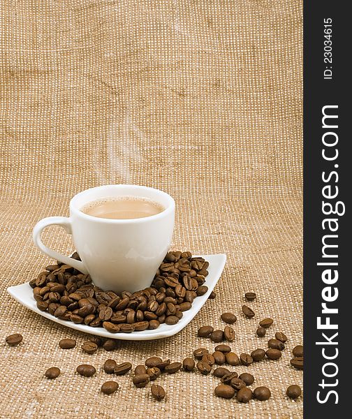 Coffee and milk and saucer with grains on a background sacking