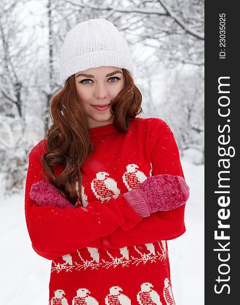 Portrait of beautiful young red hair woman outdoors in winter looking at camera and enjoying snow