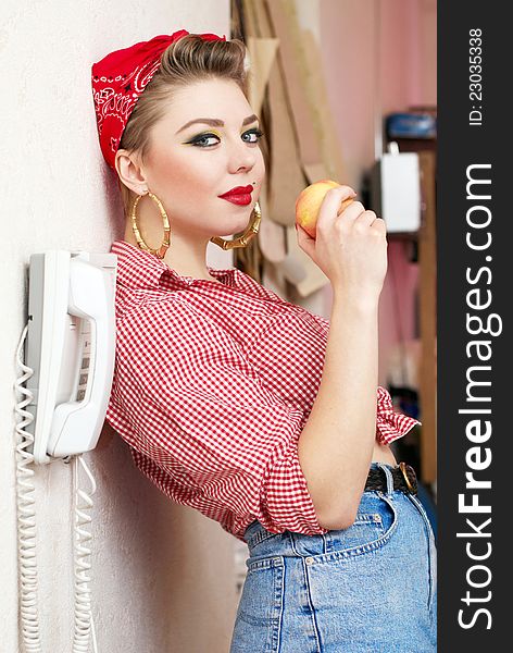 Beautiful and fashion young woman with a pin-up look. posing with a vintage phone