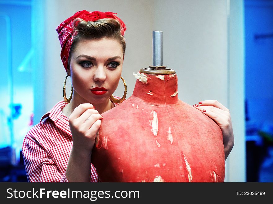 Beautiful and fashion young woman with a pin-up look. posing with a vintage mannequin