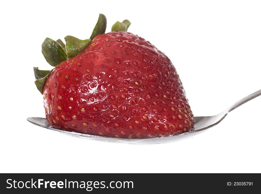 Strawberry on the spoon isolated over white background