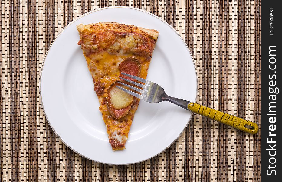 A slice of pizza with fork on white plate, good for your articles