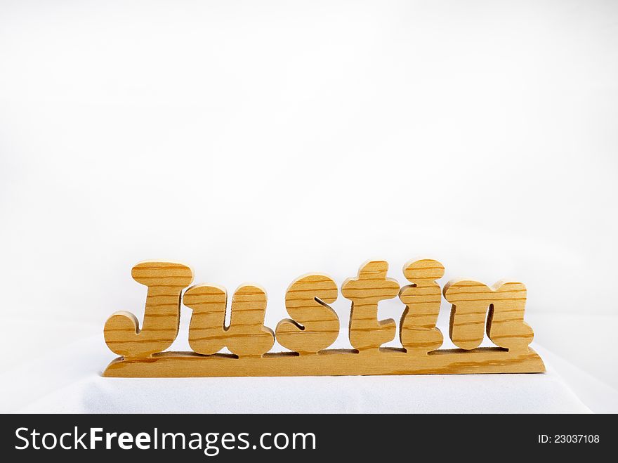 A wooden name plate with the name of Justing on it. A wooden name plate with the name of Justing on it.