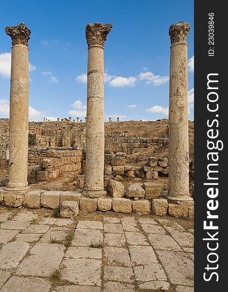 Three ancient vertical columns with capstones along the Roman road in Jerash, Jordan. Three ancient vertical columns with capstones along the Roman road in Jerash, Jordan