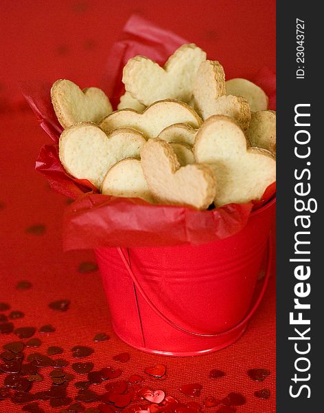 Heart shaped cookies in a red bucket. Heart shaped cookies in a red bucket