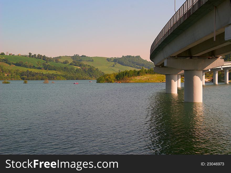 Panoramic sunset landscape lake in Italy and the bridge