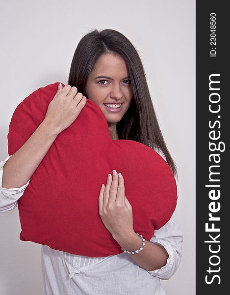 Young girl photographed on white background with big Valentine heart