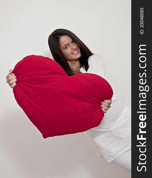 Young girl photographed on white background with big Valentine heart