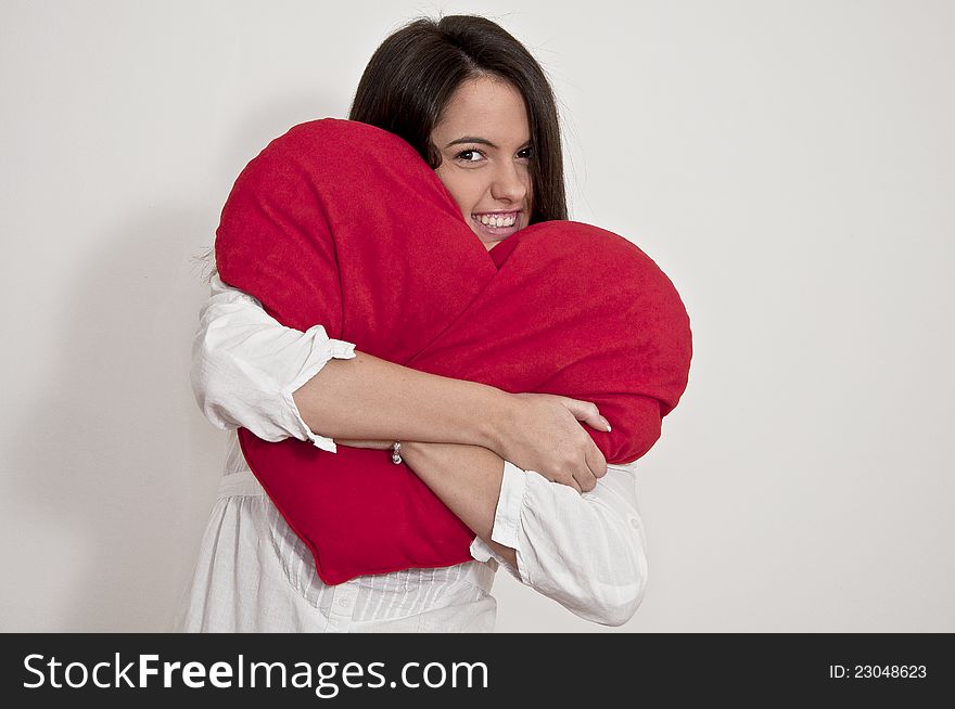 Young girl photographed on white background with big Valentine heart