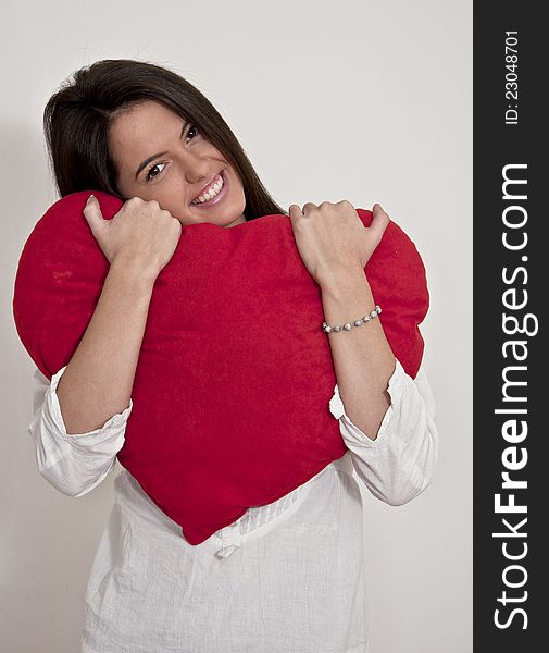 Young girl photographed on white background with big Valentine heart