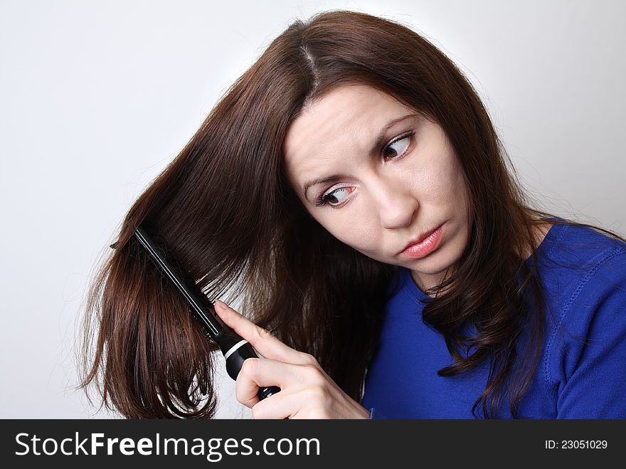 Young woman is struggling to brush her hair. Young woman is struggling to brush her hair