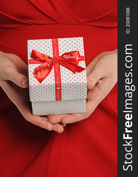 Mid section of woman holding gift box with red ribbon. Mid section of woman holding gift box with red ribbon