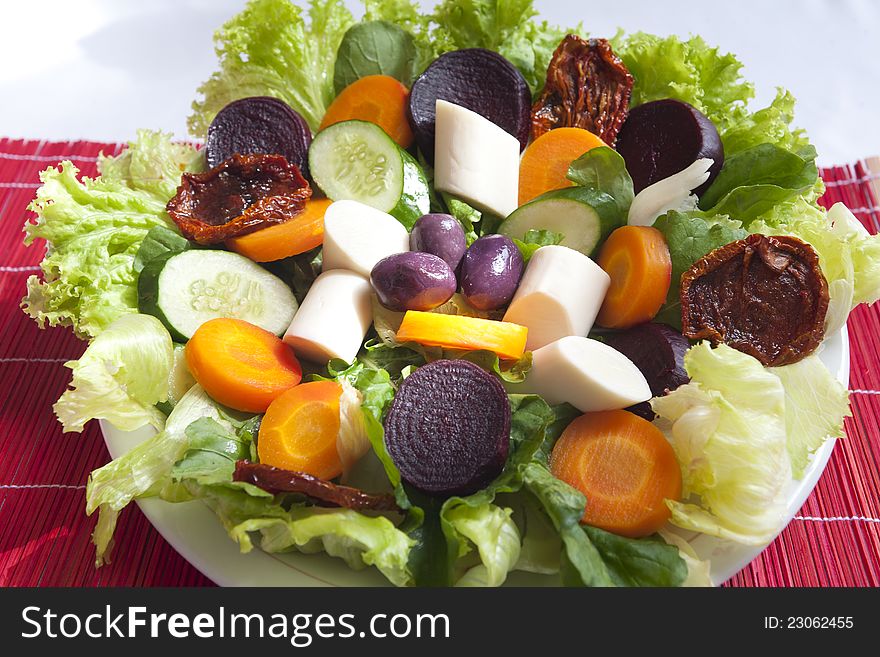 healthy mixed salad of green leaves, hearts of palm, beets and carrots