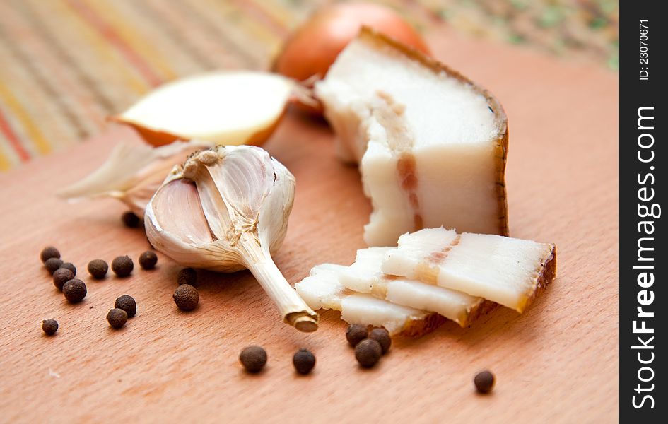 Garlic and ham on a kitchen cutting board. Garlic and ham on a kitchen cutting board