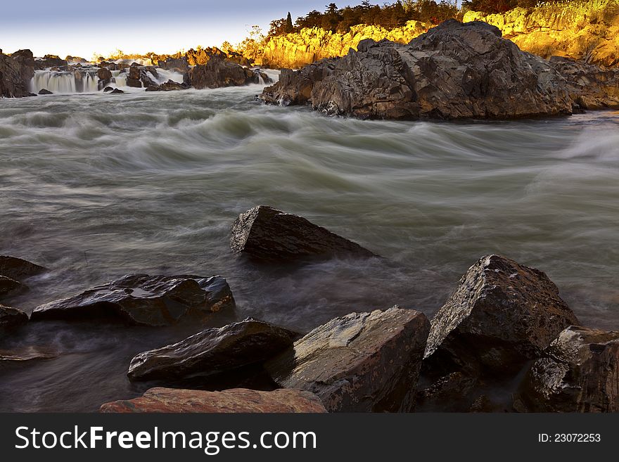 White water river with silky flow in warm sunset light. White water river with silky flow in warm sunset light