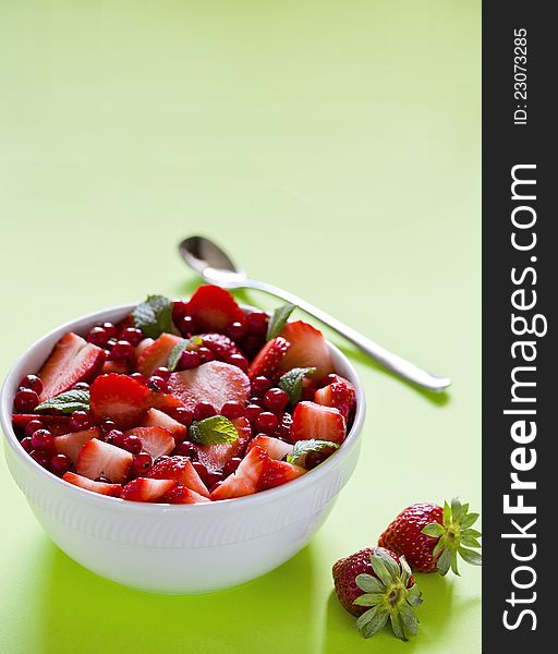 Photograph of a bowl of red fruits salad. Photograph of a bowl of red fruits salad