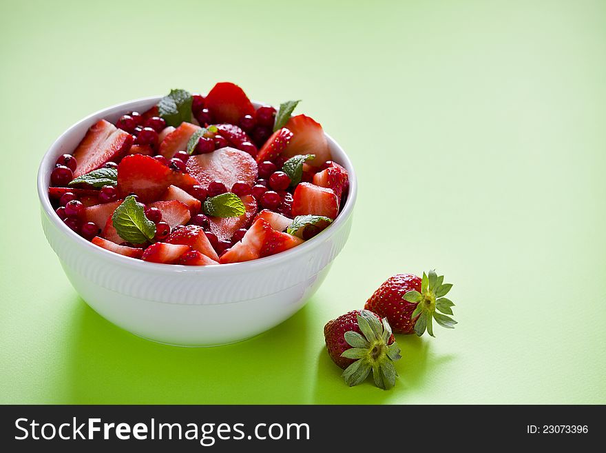 Photograph of a bowl of red fruits salad. Photograph of a bowl of red fruits salad