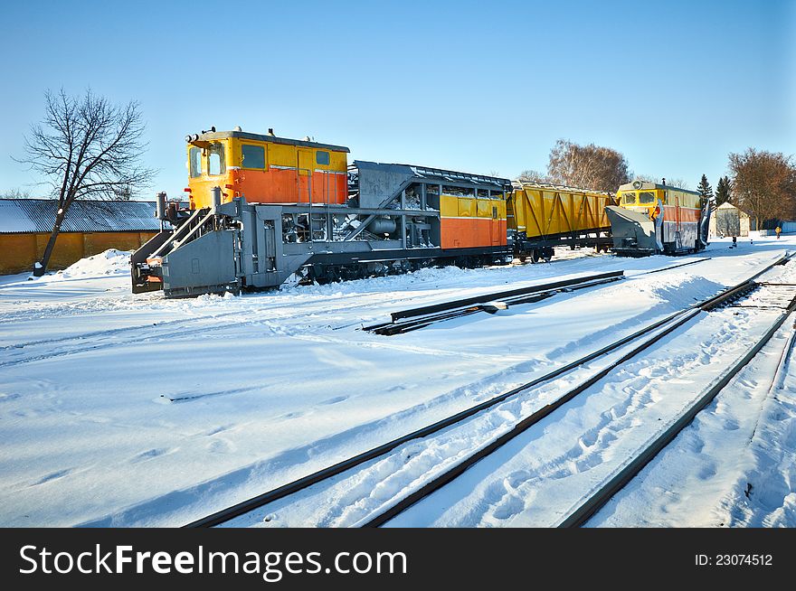 Railway locomotives for snow removal and repair of the railway against a winter landscape